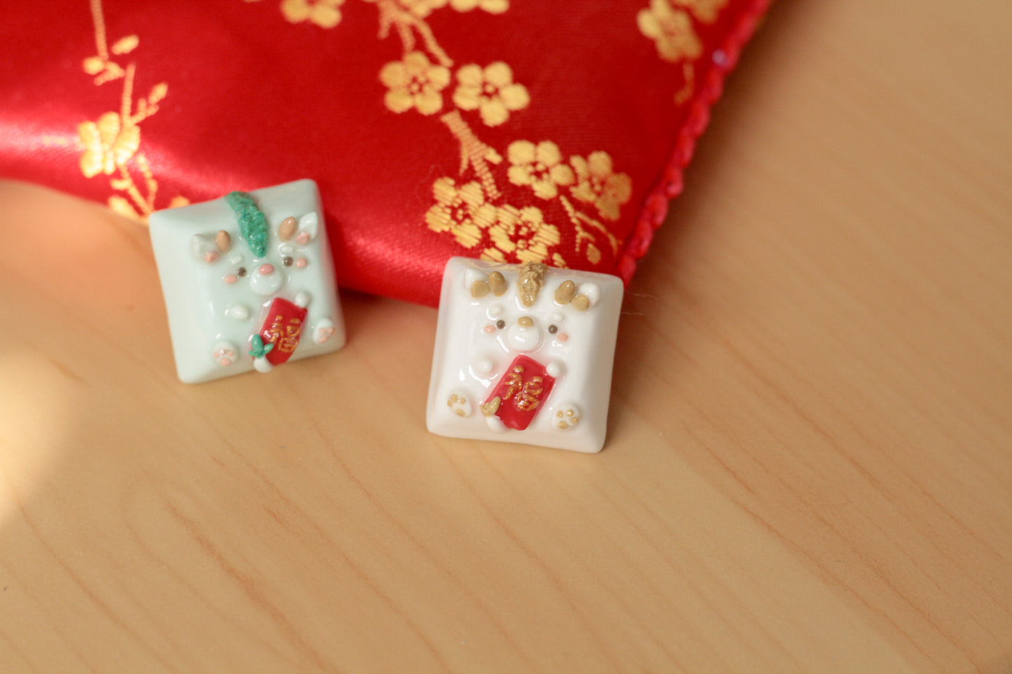 New Year Dragons in light green & white/gold color variations. Both holding a red envelope.