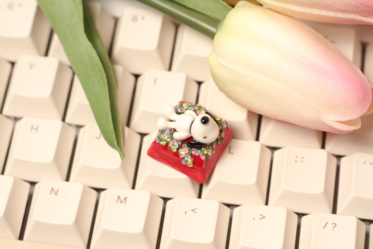 Classic Snoopy sleeping on top of his iconic red dog house on a bed of flowers.