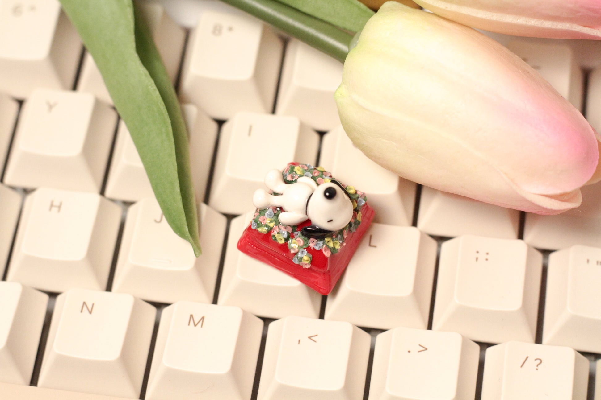Classic Snoopy sleeping on top of his iconic red dog house on a bed of flowers.
