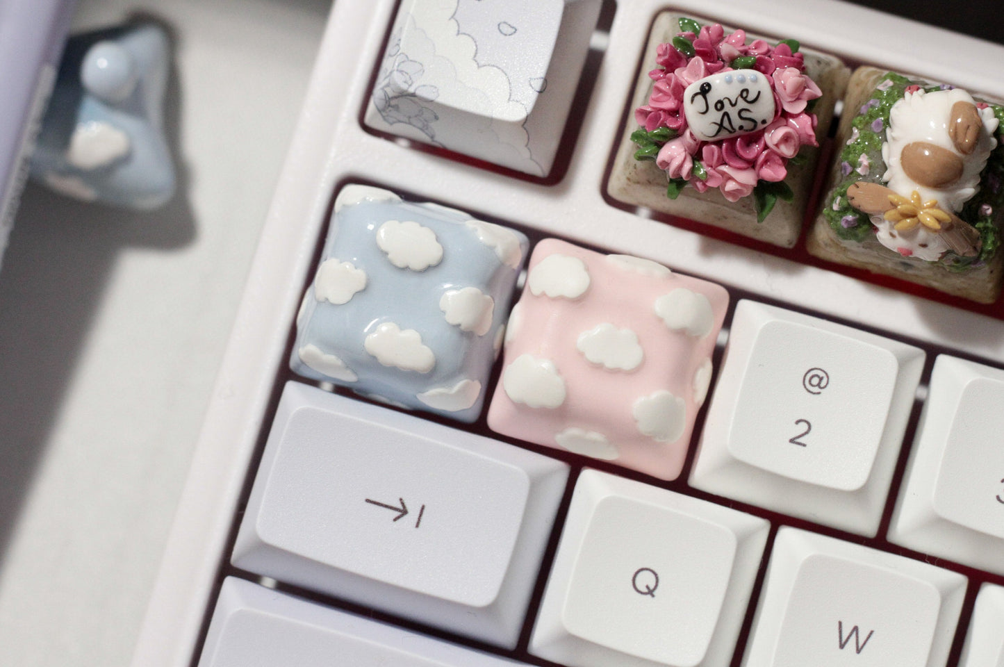 Cute Clouds Polymer Clay keycaps in pastel blue and pastel pink.