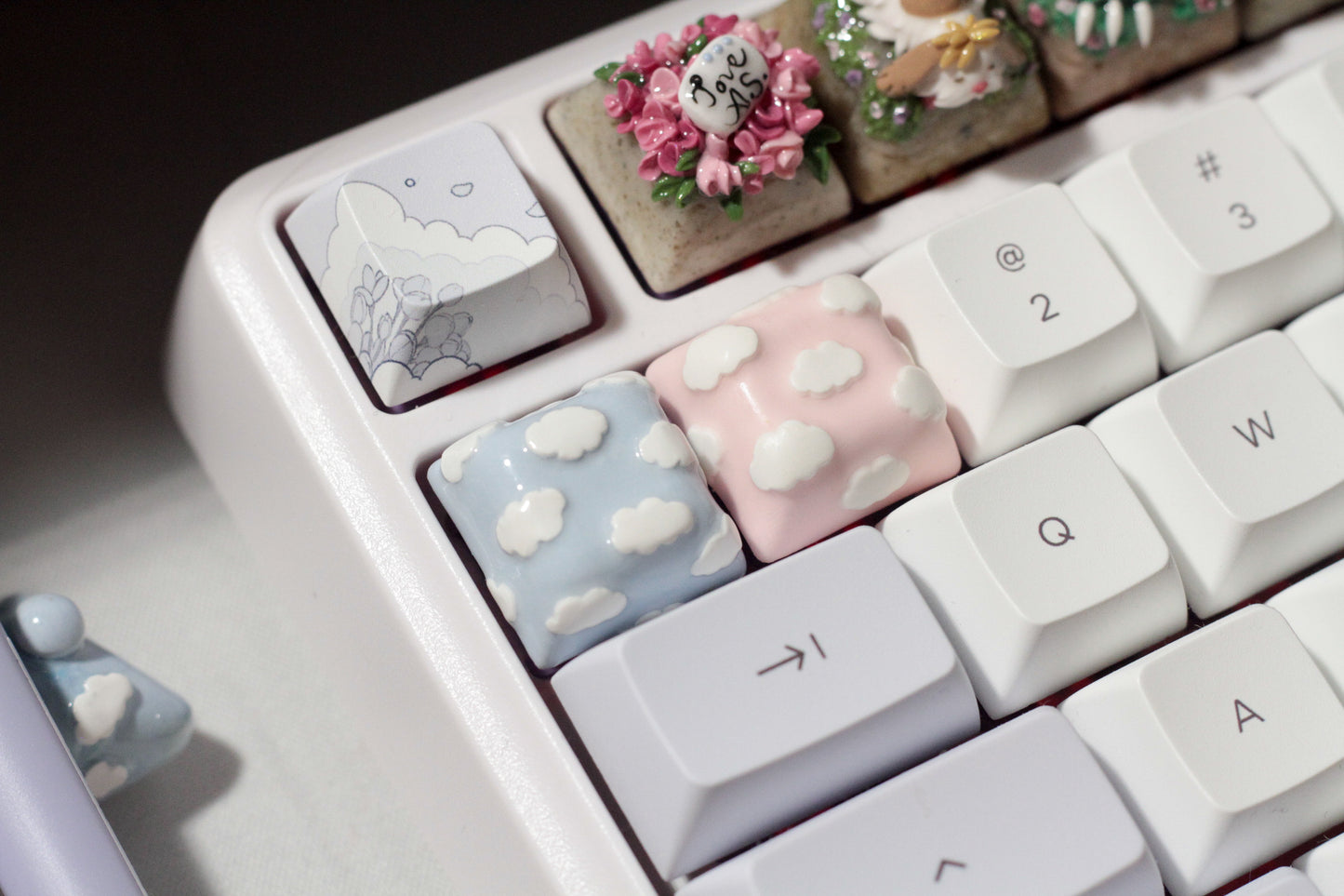 Cute Clouds Polymer Clay keycaps in pastel blue and pastel pink.