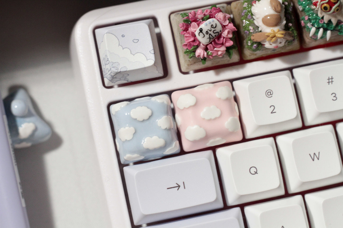 Cute Clouds Polymer Clay keycaps in pastel blue and pastel pink.